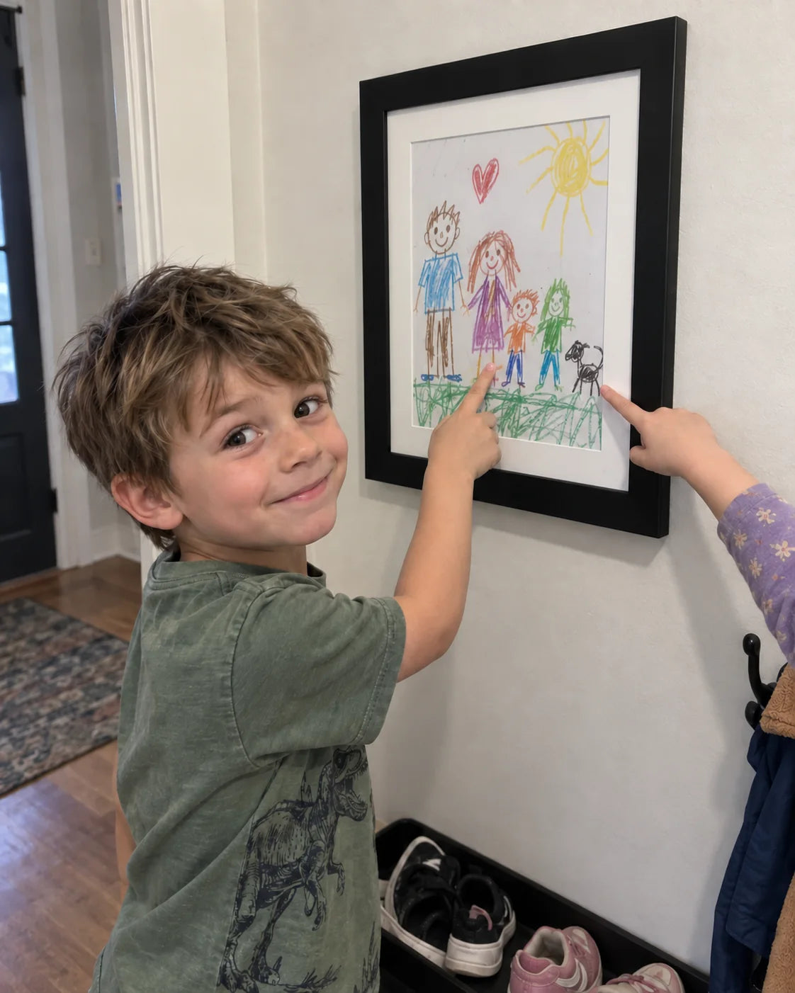 A child showing the artwork they chose to display