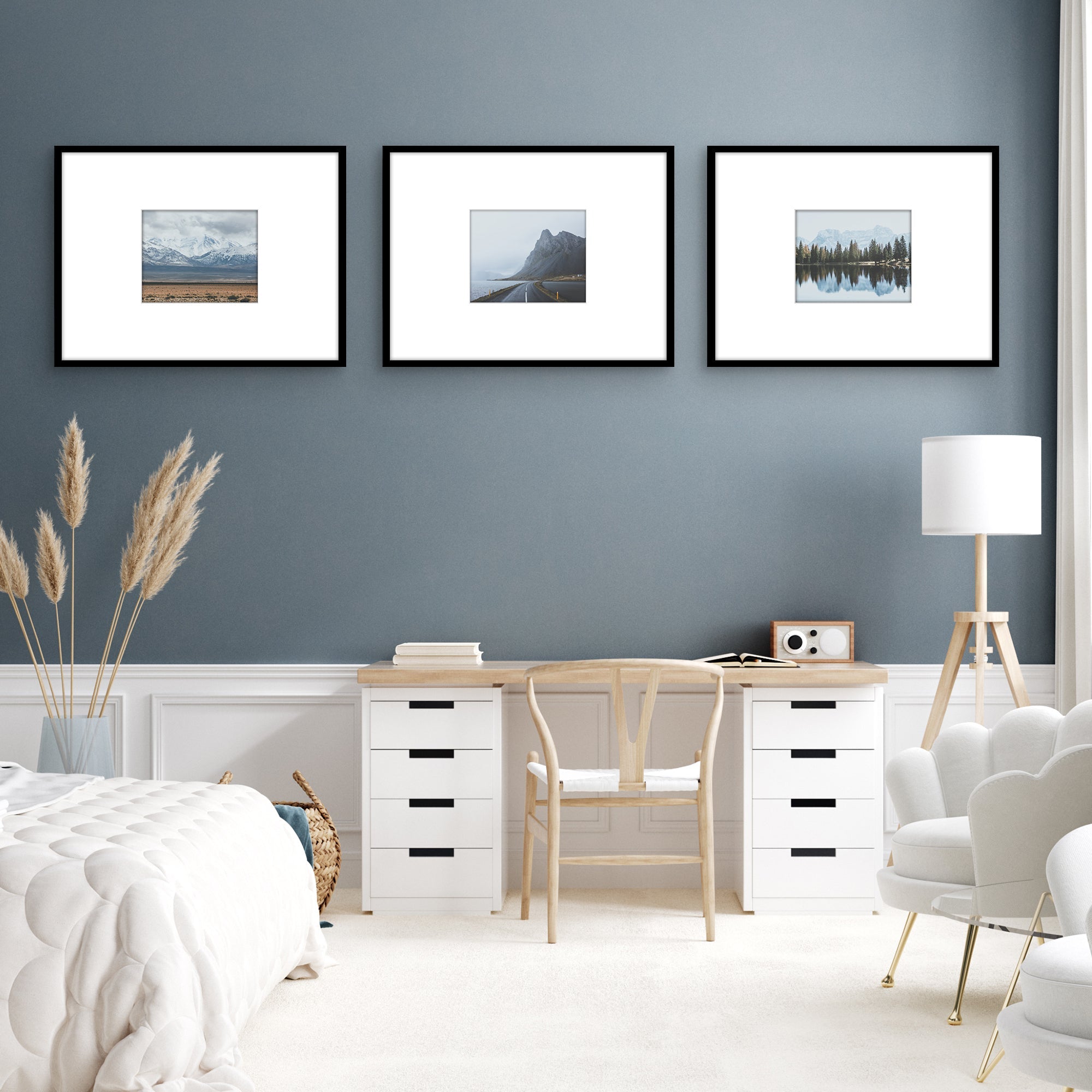 Three framed landscape photographs on blue wall. 