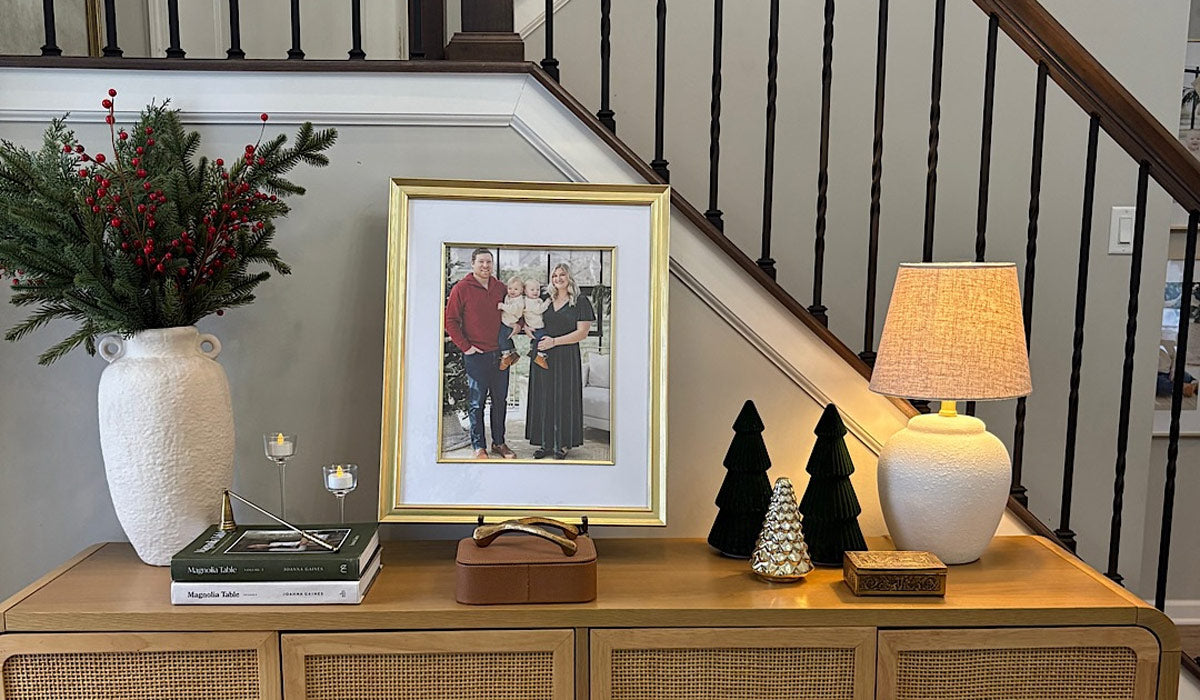 Gold matted family photo frame on a wooden console table