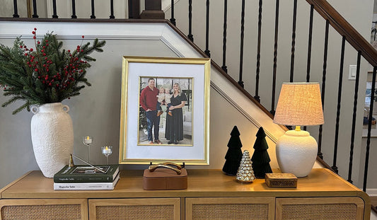Gold matted family photo frame on a wooden console table