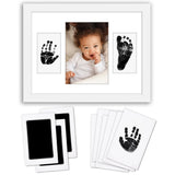 White keepsake frame holding a baby photo between inked hand and footprints 