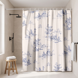 Shower curtain of blue toile pastoral scenes on cream in a walk-in shower beside a black rain head and stool 