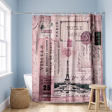 Pink Paris postcard shower curtain, the Eiffel Tower and stamps in a blue bathroom beside a freestanding tub and basket 