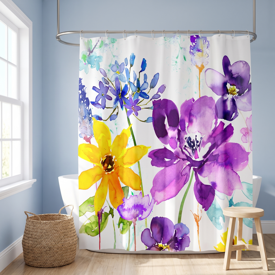 Floral shower curtain of purple and yellow watercolour blooms in a blue bathroom beside a freestanding tub and basket #flat