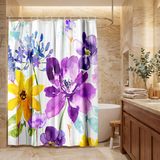 Floral shower curtain of purple and yellow watercolour blooms in a wood and stone bathroom beside folded towels 