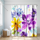 Floral shower curtain of purple and yellow watercolour blooms in a bright white bathroom beside a tub and basket 