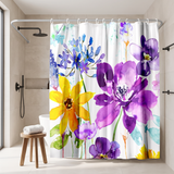 Floral shower curtain of purple and yellow watercolour blooms in a walk-in shower beside a black rain head and stool 