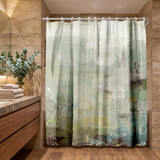 Abstract shower curtain in sage, teal and grey washes in a wood and stone bathroom beside folded towels 