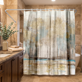 Shower curtain of a misty gold and teal woodland in a wood and stone bathroom beside folded towels 