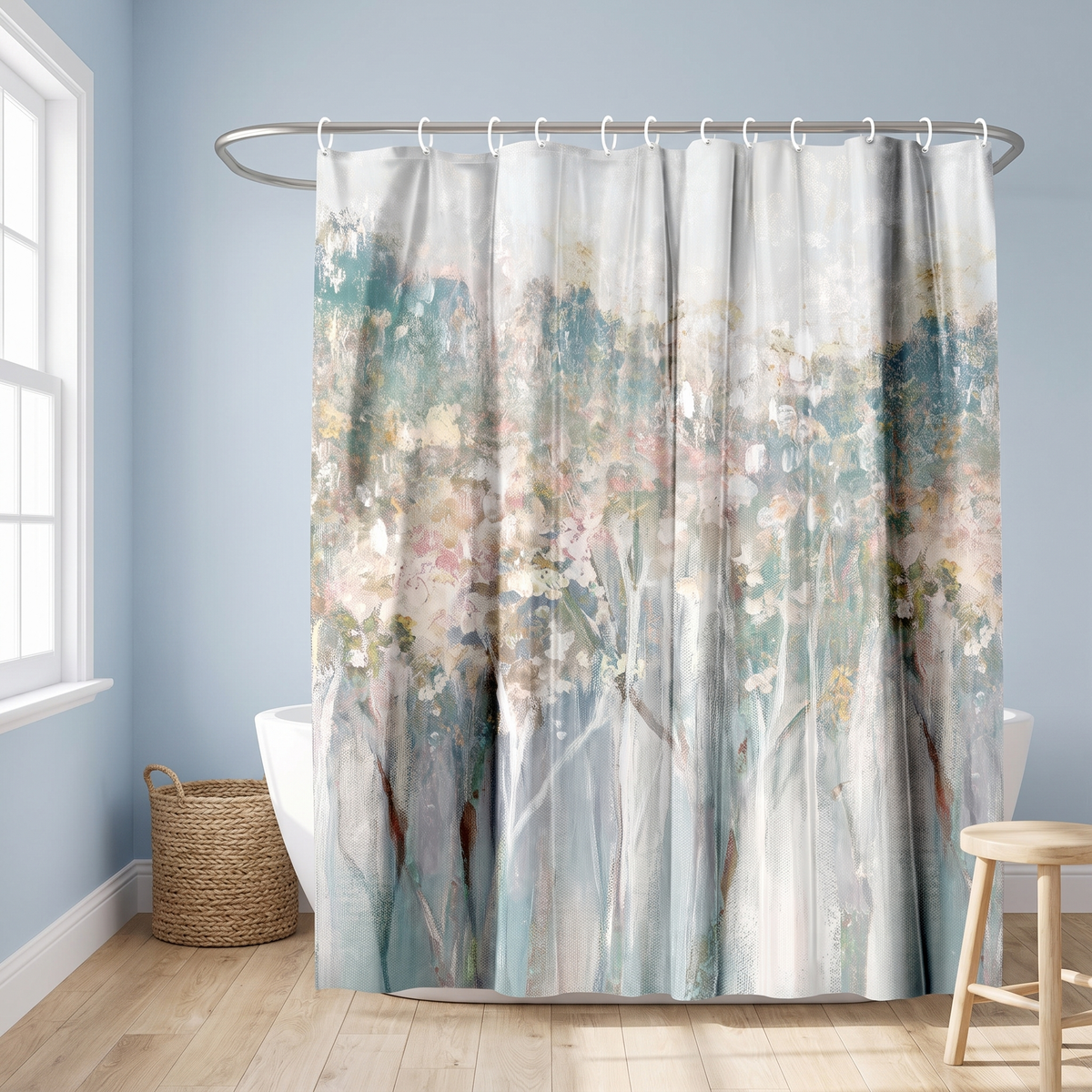 Abstract shower curtain of misty blossom trees in blush and teal in a blue bathroom beside a freestanding tub and basket 