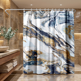 Abstract shower curtain of navy, gold and white marbled swirls in a wood and stone bathroom beside folded towels 