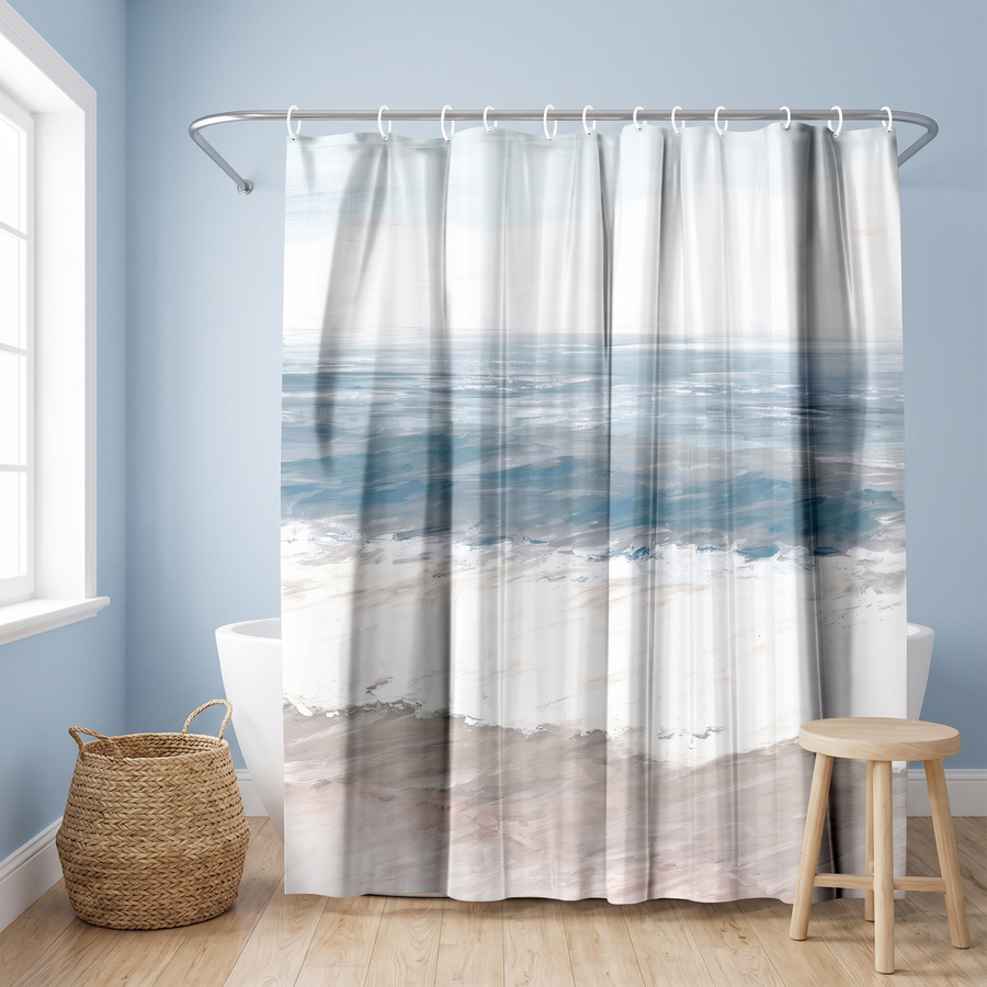 Shower curtain of soft teal sea, white surf and pale sand bands in a blue bathroom beside a freestanding tub and basket #flat
