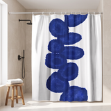 Shower curtain with a column of deep navy ink blots on white in a walk-in shower beside a black rain head and stool 