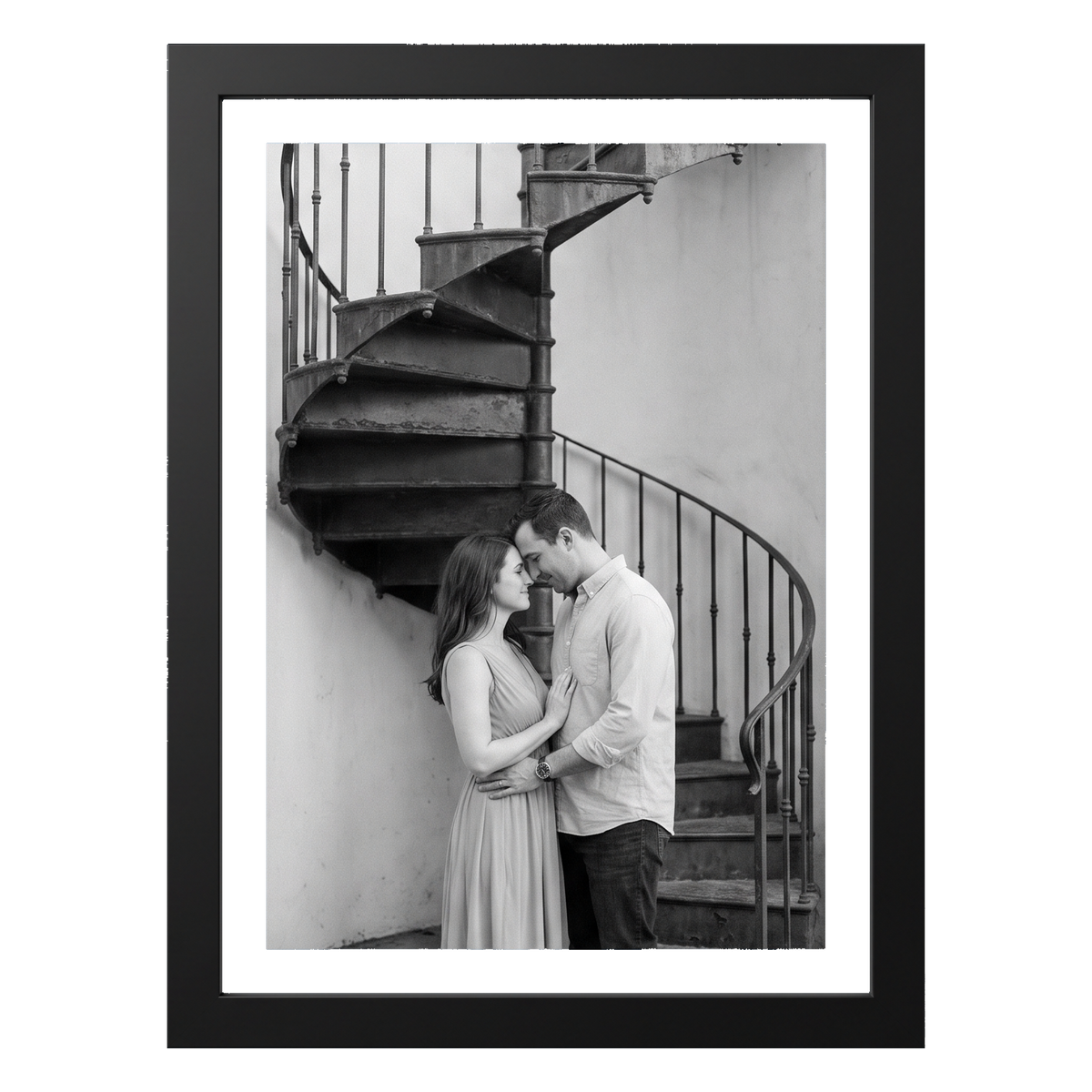Black 5x7 aluminium float frame, a black-and-white photo of a couple by a spiral staircase 