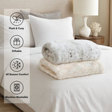 Stack of plush blankets on a bed with features highlighted.