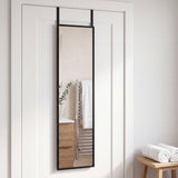 Black 12x48 over-the-door mirror on a white bathroom door, reflecting pale tile, a heated towel rail and eucalyptus