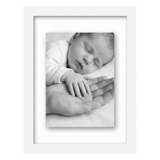 White 8.5x11 float frame, a newborn's hand resting on an adult palm, floating on backing 