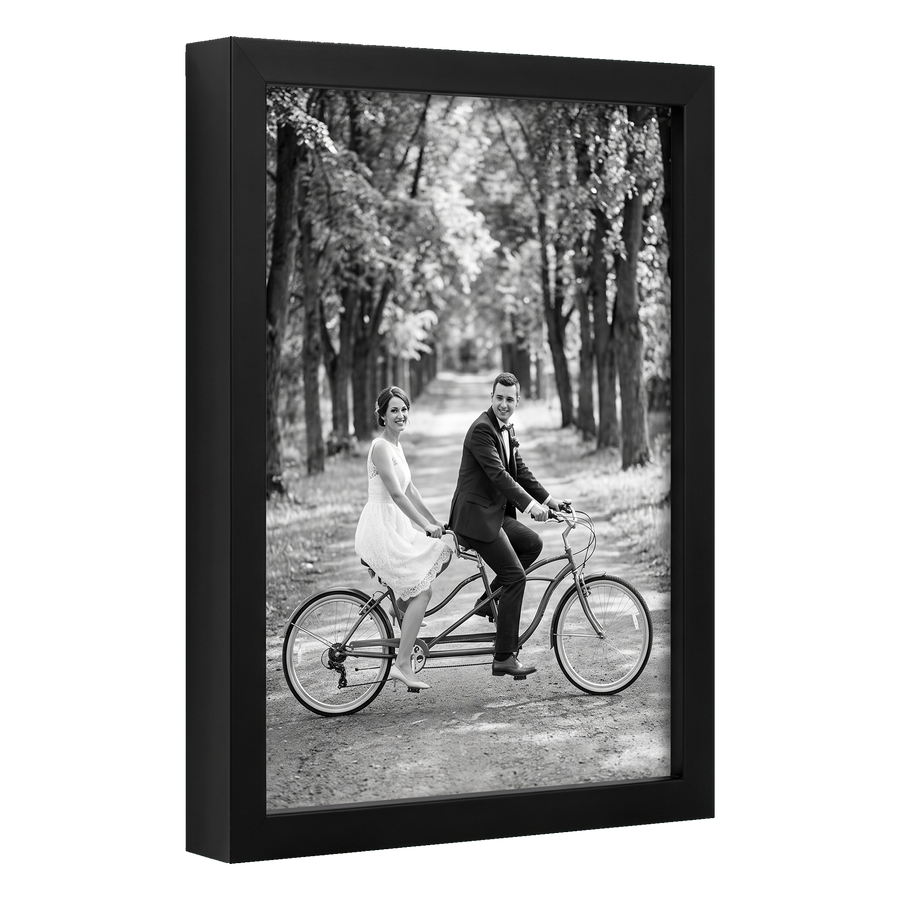 Angled black 8x12 deep frame, a bride and groom riding a tandem bicycle 