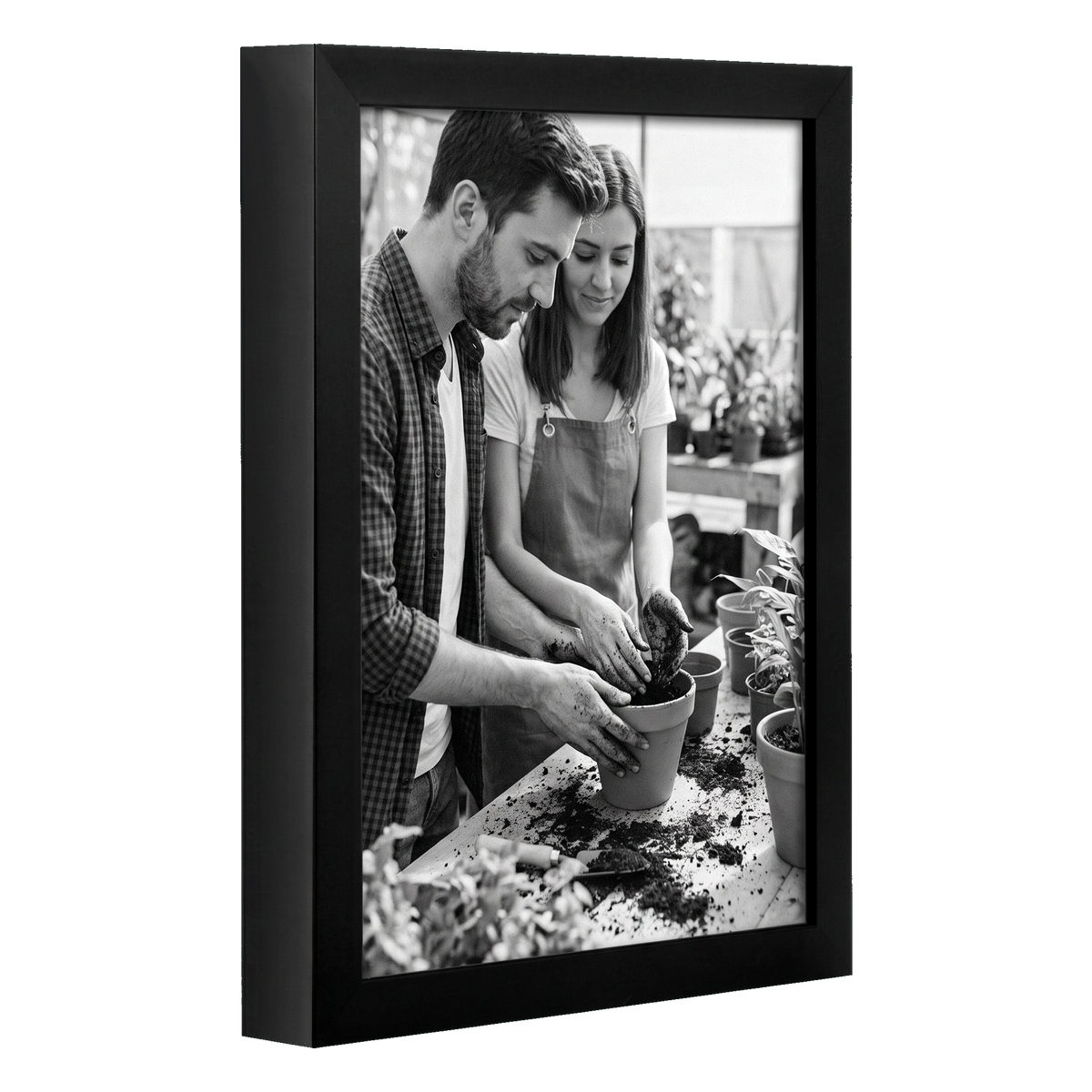 Angled black 8.5x11 deep frame, a couple potting a plant at a garden bench 