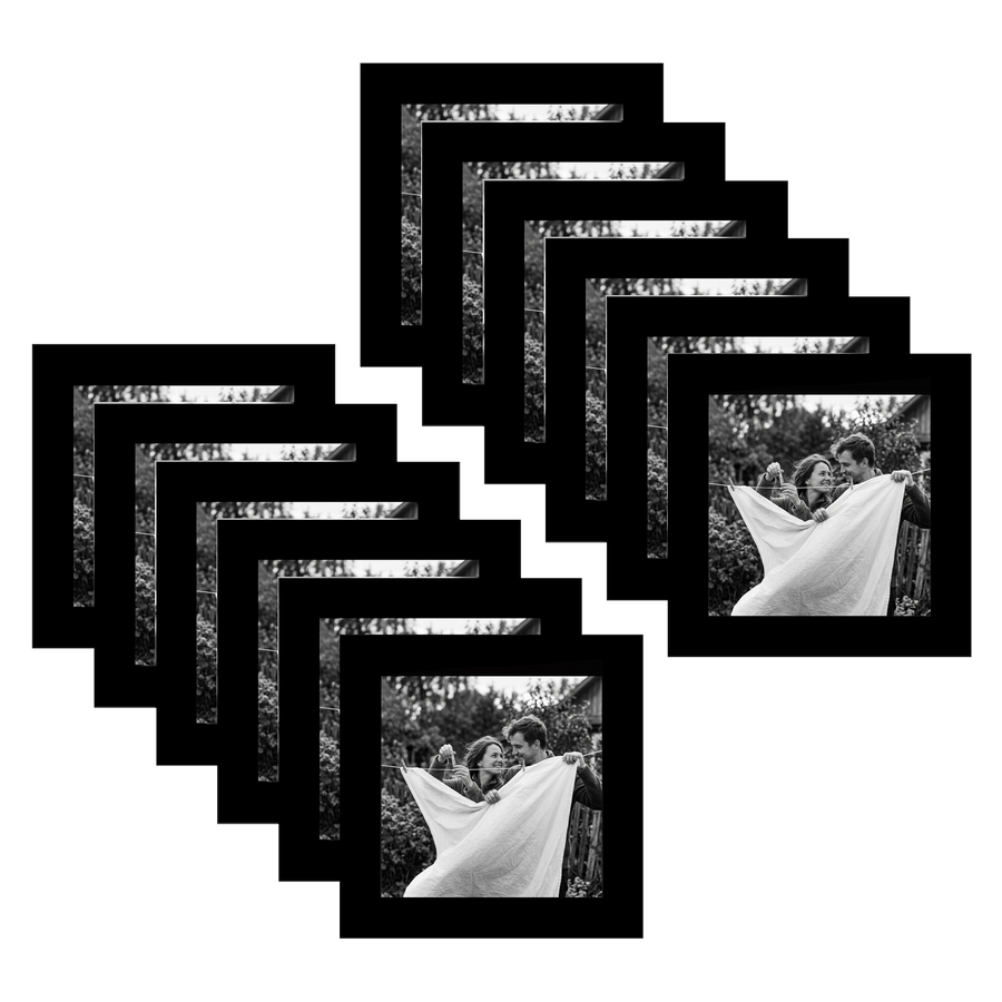 Twelve black 4x4 square frames fanned, a couple wrapped in a sheet in a meadow 