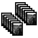 Twelve black 6x8 frames fanned, a couple leaning together on a field fence 