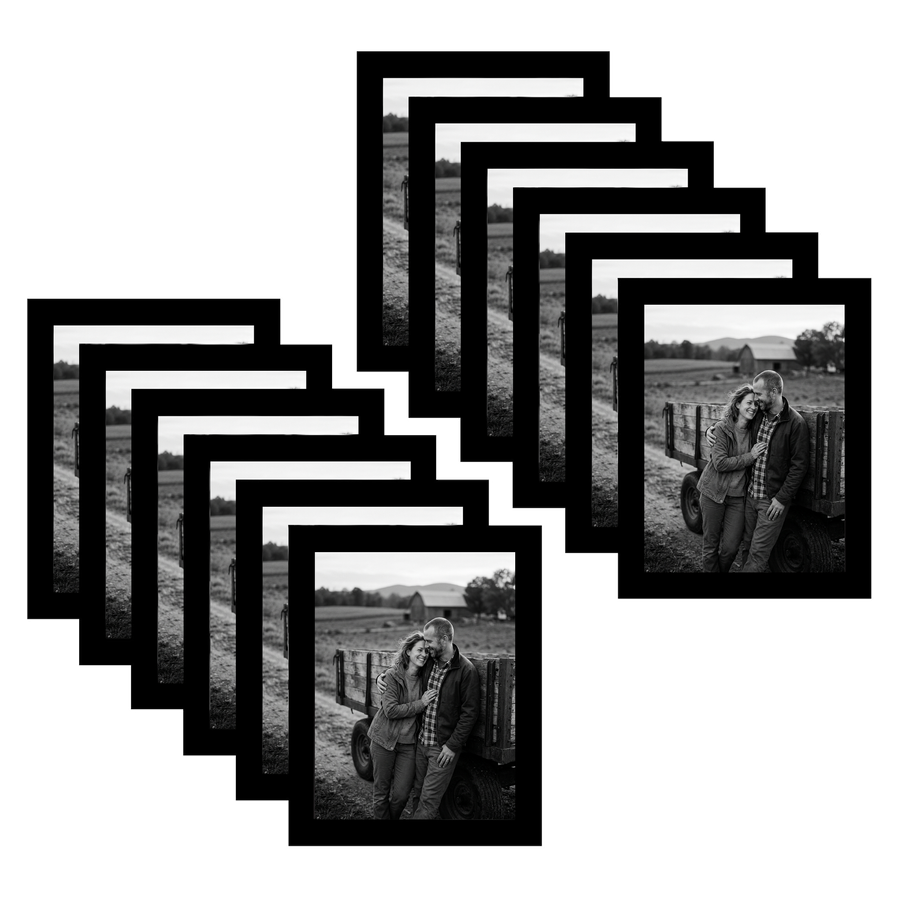 Twelve black 6x8 frames fanned, a couple leaning together on a field fence 