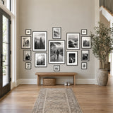 Grand Gallery Wall — fifteen black Hudson frames on an entryway wall above an oak bench 