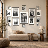 Grand Gallery Wall — fifteen black Hudson frames above a boucle daybed in a sunlit loft 