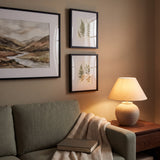 Evening detail of the gallery wall lit by a table lamp — one 16x20 and two 8x10 frames 