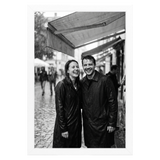 White Streamline frame, 4x6,  no mat, holding a photo of a couple in rain gear at a market 