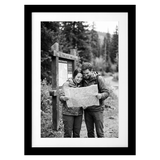 Black Streamline frame, 5x7, with a white mat, holding a photo of a couple reading a map by a trail sign 