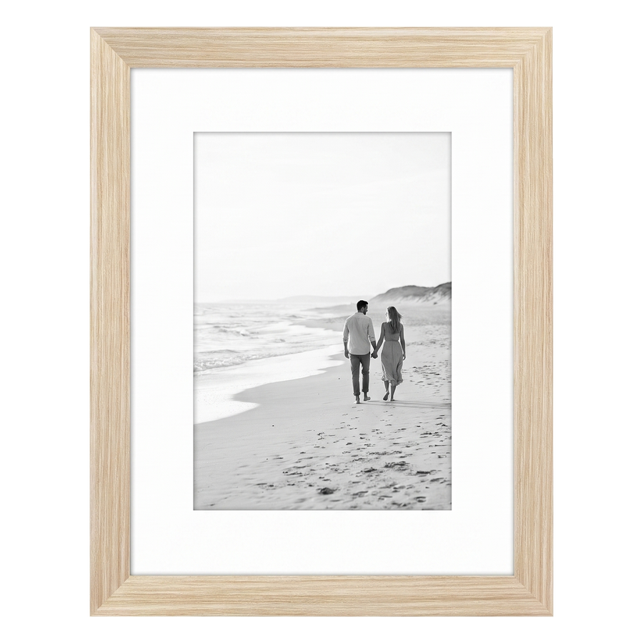 Light wood Signature frame, 8x10, with a wide white mat, holding a photo of a couple on a dune beach 