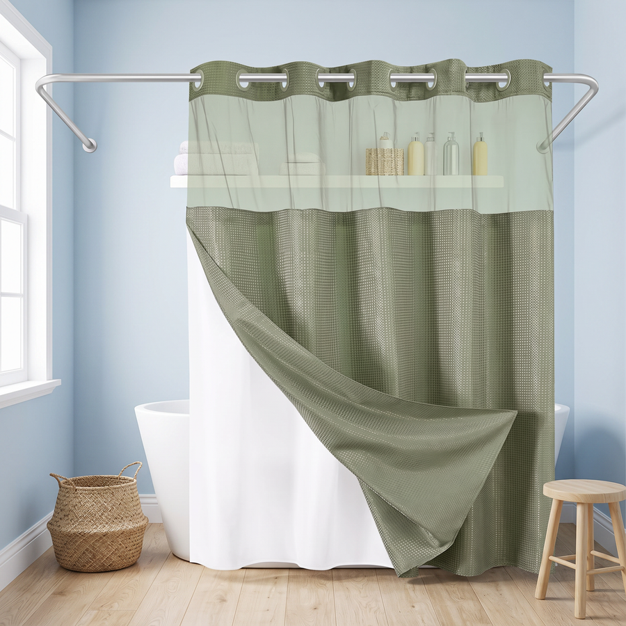 An olive green shower curtain with a textured waffle pattern and a sheer matching grommet top panel, hanging in a bright bathroom with light blue walls, a white tub, and wooden flooring. 