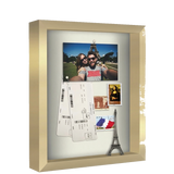 Gold 11x14 shadow box holding travel keepsakes: a photo, tickets and an Eiffel Tower model 