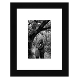 Black Signature frame, 6x8, with a wide white mat, holding a photo of a couple under a tree 