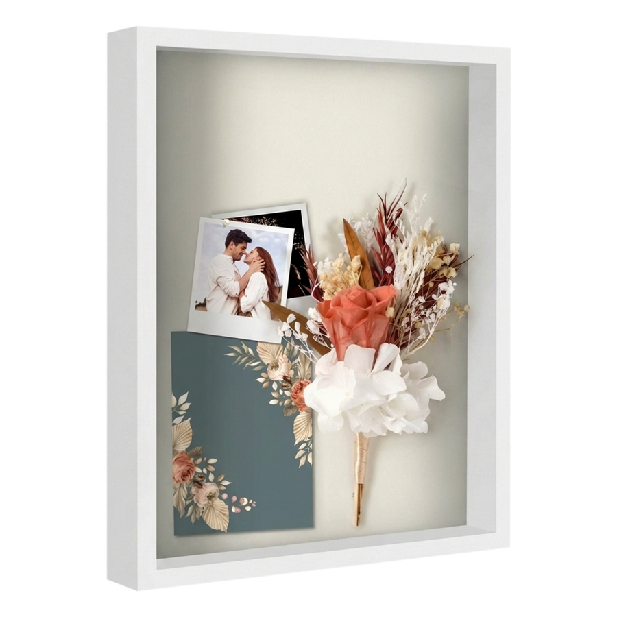 White 16x20 shadow box holding a wedding photo, dried flowers and an invitation 