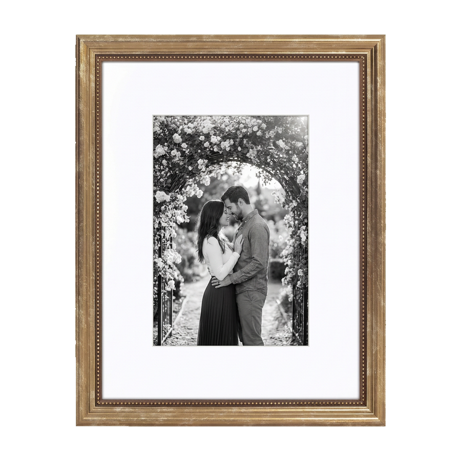 Gold beaded Heirloom frame, 11x14, holding a black-and-white photo of a couple beneath a rose-covered arch
