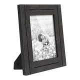 Angled black distressed 6x8 Hampton frame on its easel stand, a woman in a flower meadow 