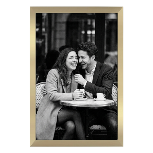 Gold Epic poster frame, 12x18, no mat, holding a black-and-white photo of a couple laughing at a cafe table #flat