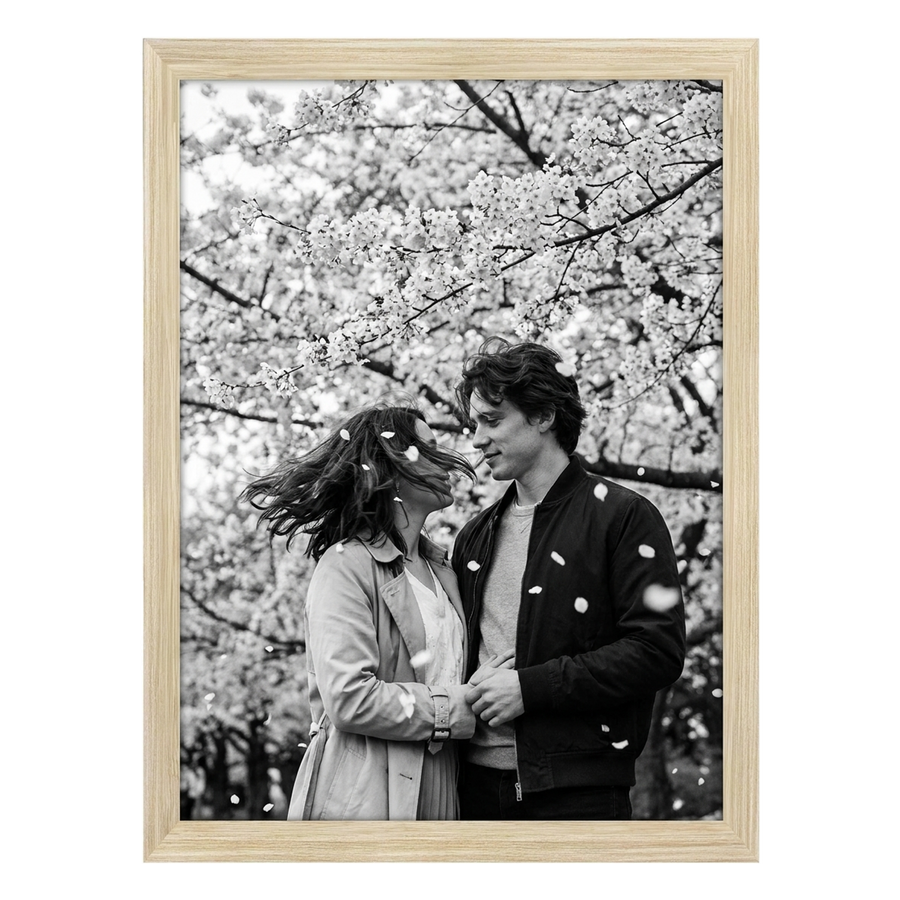 Natural oak Epic poster frame, 18x24, no mat, holding a black-and-white photo of a couple under blossom 