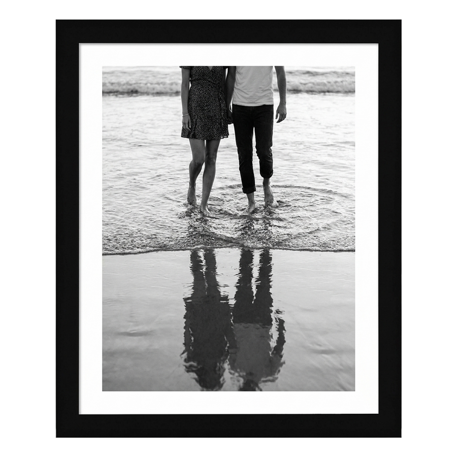 Black Epic poster frame, 20x24, holding a black-and-white photo of a couple wading, with a wide white border 