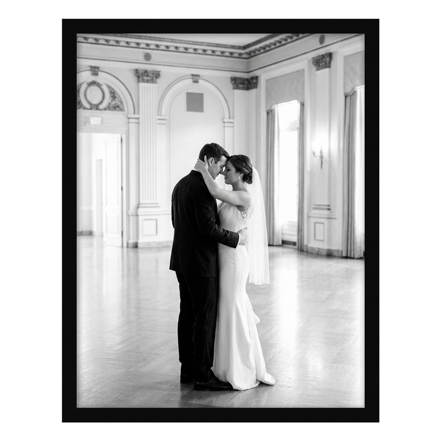 Black Epic poster frame, 24x30, no mat, holding a black-and-white photo of a bride and groom in a grand hall 