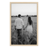 Pine Epic poster frame, 24x36, no mat, holding a black-and-white photo of a couple in a wheat field 
