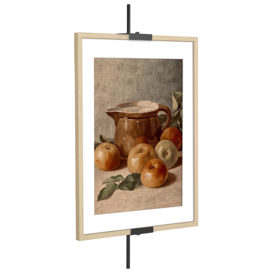 Black 30 inch wall easel rail clamping a light wood matted frame of a jug and apples 