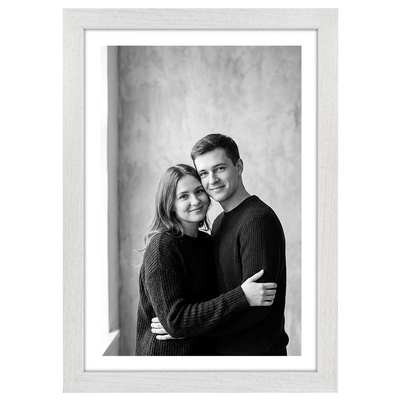 White woodgrain Hudson frame, 13x19, with an 11x17 white mat, holding a black-and-white studio portrait of a couple #flat