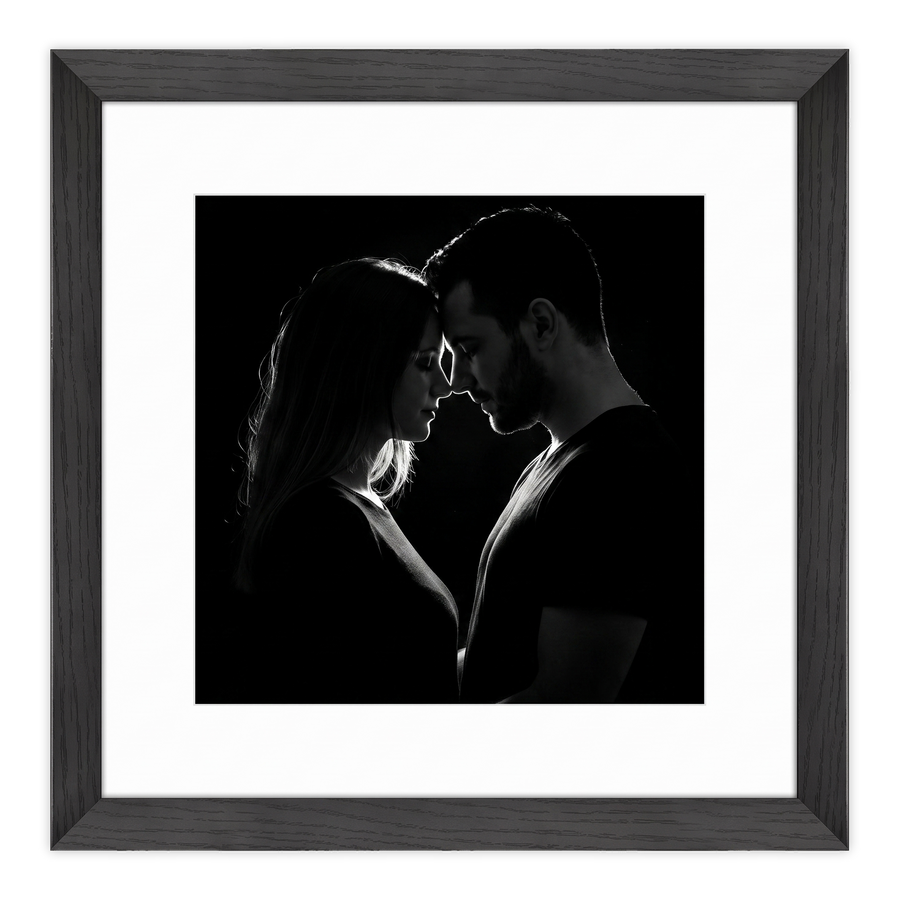 Black Hudson frame, 16x16, with a 12x12 white mat, holding a low-key black-and-white photo of a couple face to face 