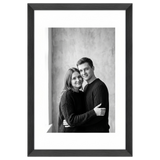 Black Hudson frame, 16x24, with a 12x18 white mat, holding a black-and-white studio portrait of a couple embracing 