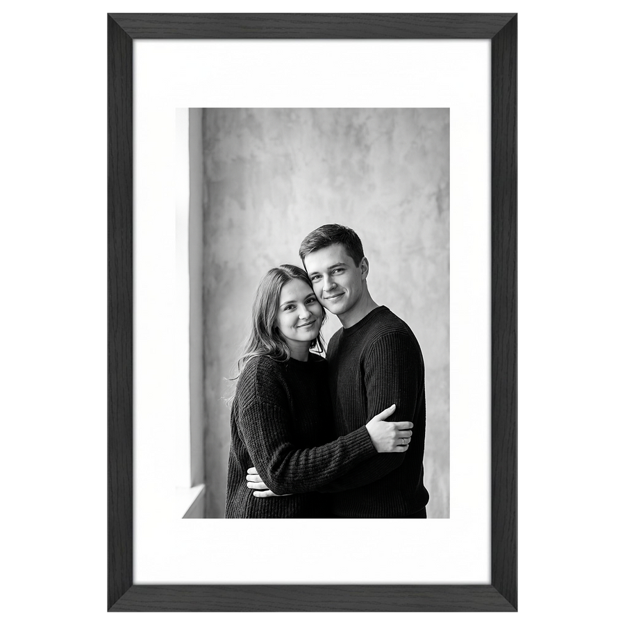 Black Hudson frame, 16x24, with a 12x18 white mat, holding a black-and-white studio portrait of a couple embracing #flat