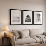 The three-frame row above a linen sofa in a living room 