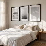 The three frames above a bed in a bright bedroom 